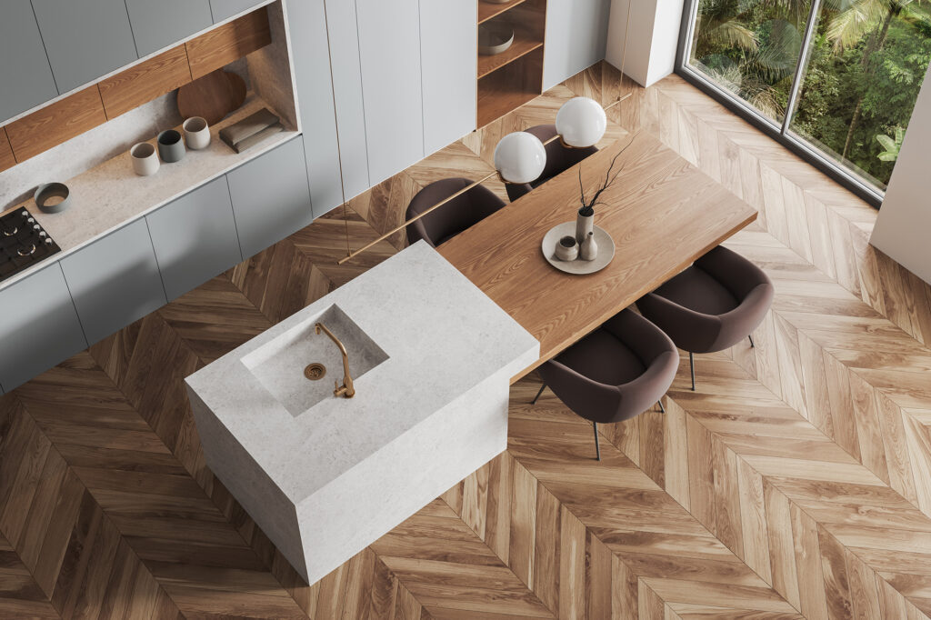 Chevron pattern hardwood flooring in a warm earth toned kitchen and dining space