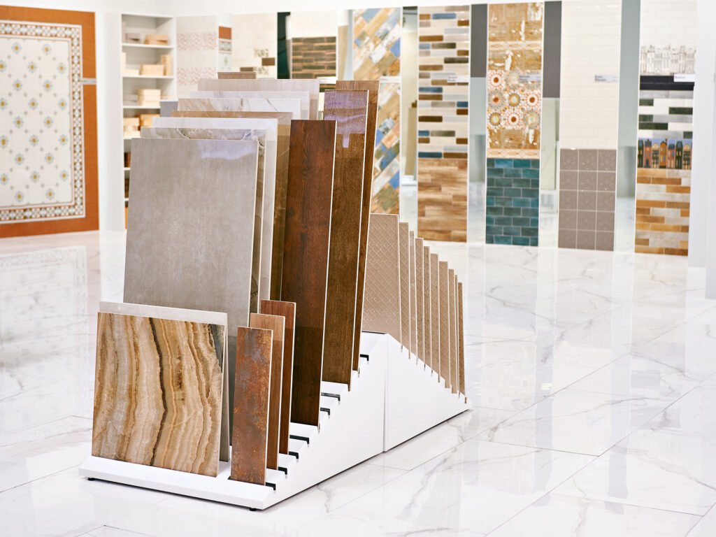 Assorted tile and wood look plank samples displayed on a showroom wall