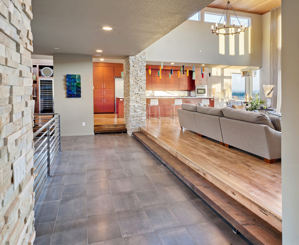 Tile flooring transitioning to hardwood flooring in an open concept living space