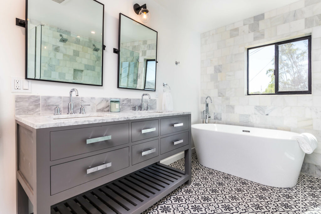 Small bathroom with patterned floor tile and a marble tiled shower wall